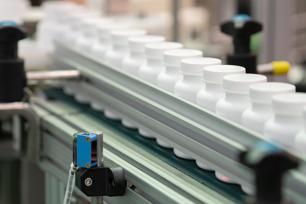 Etikettierung von Arzneimittelflaschen auf Förderband